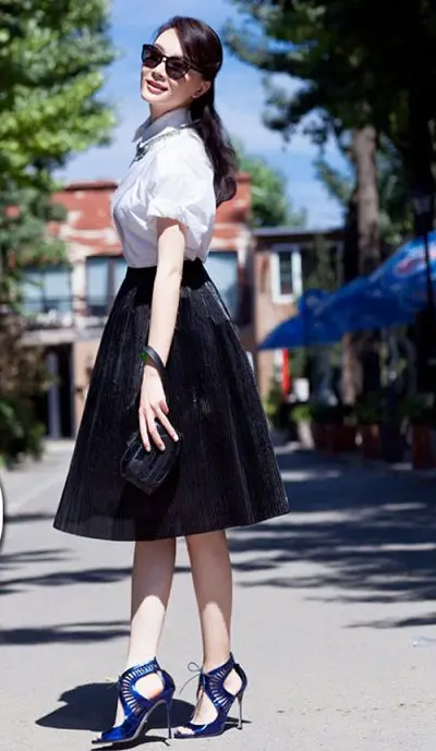 Một chiếc váy xếp ly xòe với phom cứng chất vải nặng mặc cùng áo sơ mi trắng sẽ khiến giáo viên trẻ hơn