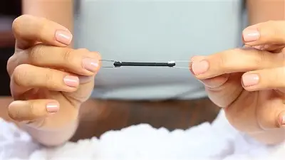 Luồn hai đầu dây vào hai chiếc kim băng