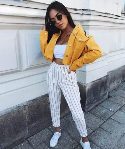 Áo quây croptop kết hợp với quần baggy kaki họa tiết kẻ sọc cùng tont nổi bật, thêm một chiếc áo khoác kaki có màu sắc sặc sỡ tô điểm thêm cho set đồ cũng như khiến bộ trang phục không bị quả hở hang và phản cảm